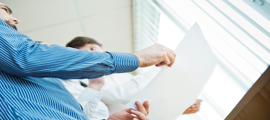 Two people holding a large sheet of paper