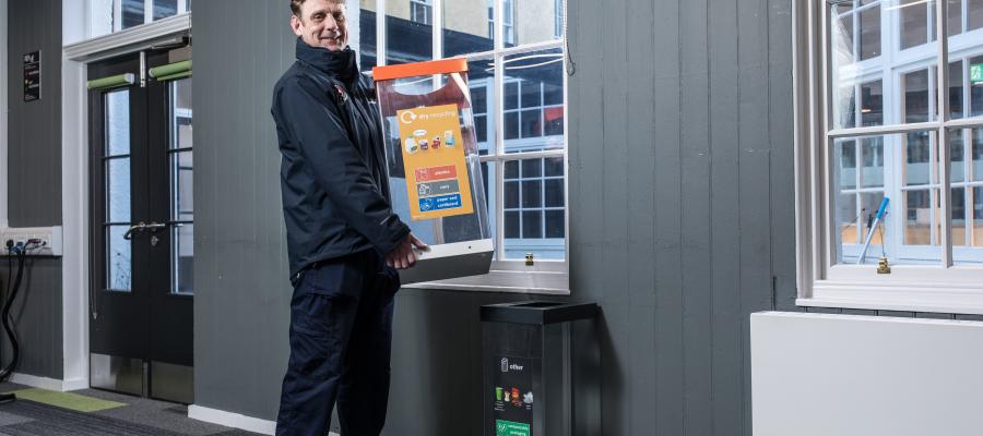 Waste team member holding recycling bin 