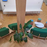 Looking down at a room with green sofas and small coffee tables