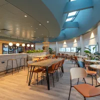 A curved room with tables and chairs and windows looking outside 
