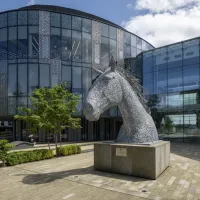 Glass building with large horse statue in front