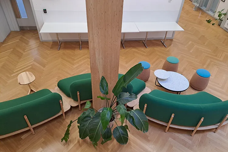 Looking down at a room with green sofas and small coffee tables