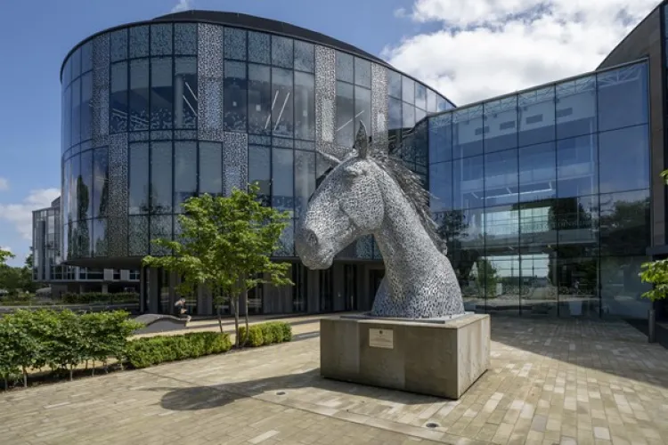 Glass building with large horse statue in front